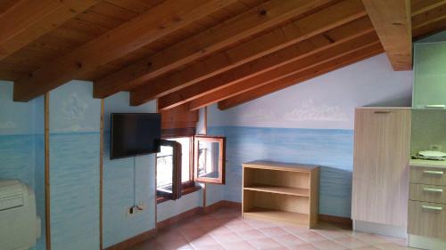 una cucina con pareti blu e una TV a parete di Mansarda Ariel a Limone sul Garda