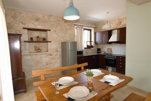 a kitchen with a wooden table with plates on it at LIORIZA Country Houses in Kalamaki