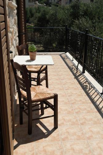 a patio with a table and chairs on a balcony at LIORIZA Country Houses in Kalamaki