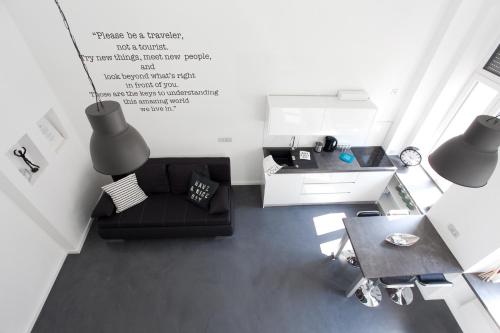 sala de estar con sofá negro y mesa en Mini Loft Design, en Budapest
