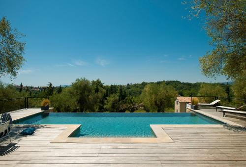 een groot zwembad met een houten terras bij Domaine de Bramafam in Plascassier