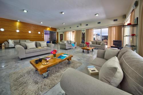 una gran sala de estar con sofás y una mesa. en Paxos Club Resort & SPA en Gaios