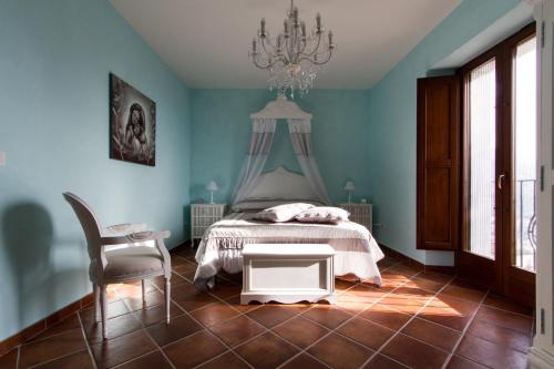 - une chambre avec un lit, une chaise et un lustre dans l'établissement La Rossa Fantastica, à Piedimonte dʼAlife