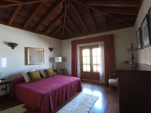 a bedroom with a purple bed and a window at Villa la petite in Guatiza