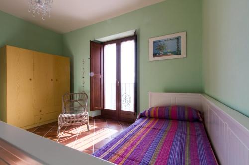 - une chambre avec un lit, une chaise et une fenêtre dans l'établissement La Rossa Fantastica, à Piedimonte dʼAlife