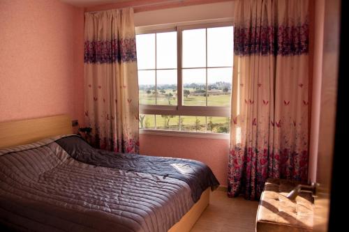 a bedroom with a bed and a large window at Apartamento Retamar in Retamar