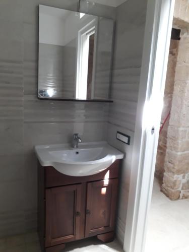 a bathroom with a sink and a mirror at Trulli Resort Grassi in Alberobello