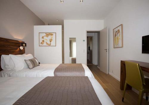 a hotel room with two beds and a desk at App-Arte Marseille Vieux-Port in Marseille