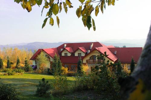 a large house with a red roof at Pensjonat Zacisze in Czchów