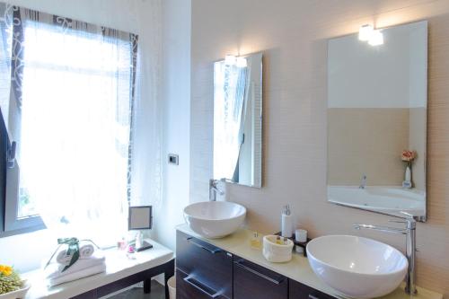 a bathroom with two sinks and a large mirror at Villa Degli Ulivi B&B in Finale Ligure