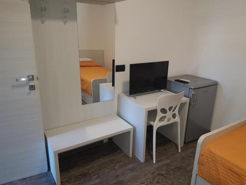 una camera da letto con scrivania, letto e specchio di Residenza Borgazzi CIR S00031 a Monza