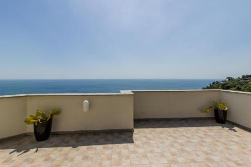 a balcony with two potted plants and the ocean at Villa Degli Ulivi B&B in Finale Ligure