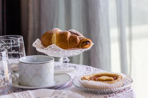 a table with a plate of bread and a cup of coffee at Villa Degli Ulivi B&B in Finale Ligure