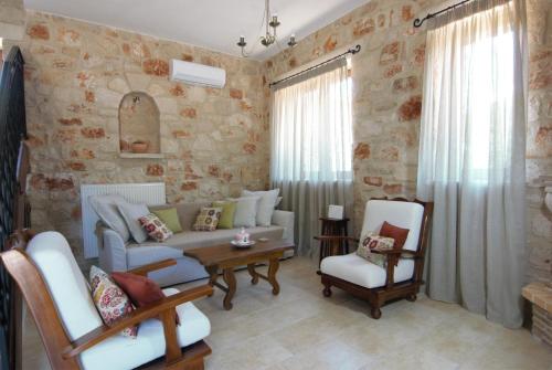 a living room with a couch and a table and chairs at LIORIZA Country Houses in Kalamaki