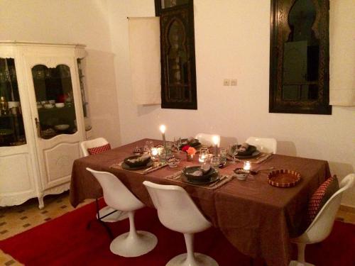 a dining room table with candles on top of it at La Maison des Ailleurs in Essaouira