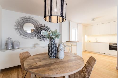 a dining room with a table and a vase with flowers at FLH Martim Moniz Terrace Flat in Lisbon