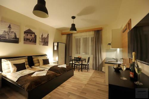a bedroom with a large bed and a kitchen at Apartmány Kukučín in Košice