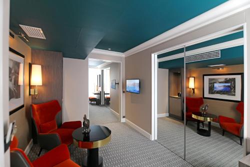 アルビにあるオテル アルチミーの赤い椅子と待合室が備わるホテルルーム