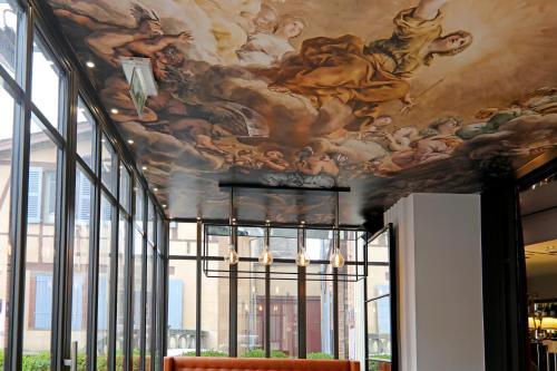 a room with a ceiling with paintings on it at Hôtel Alchimy in Albi