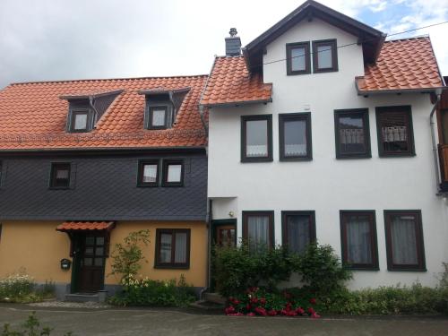 une maison blanche avec un toit rouge dans l'établissement Haus Schammes, à Wutha-Farnroda