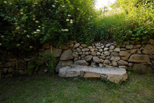 a stone wall with a stone bench in the grass at Moinho do Prado in Vila Nova de Cerveira