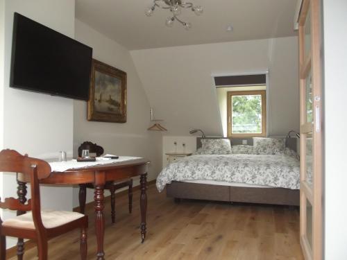 um quarto com uma cama, uma mesa e uma secretária em Au Bonheur Frontalier em Steenvoorde