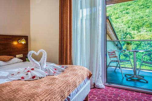 a hotel room with a bed and a balcony at Patak Park Hotel Visegrád in Visegrád
