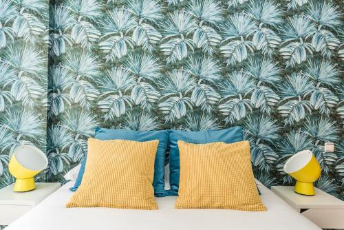 a bedroom with blue and yellow pillows and a wall at Waou Gran Via I - Alquiler Corta Duración in Madrid
