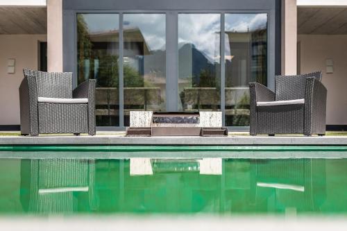 three chairs sitting next to a swimming pool at XL Appartements Sand in Taufers in Campo Tures
