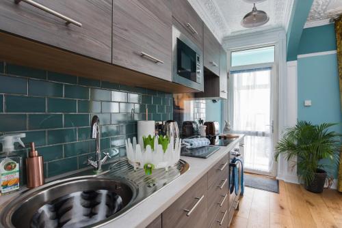 a kitchen with a sink and a counter at Beachfront Boutique Seafront APARTMENT in Aberystwyth