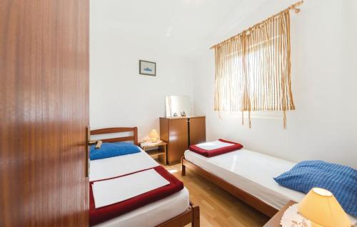 een kleine kamer met 2 bedden en een deur bij Apartman Ivanka in Vir