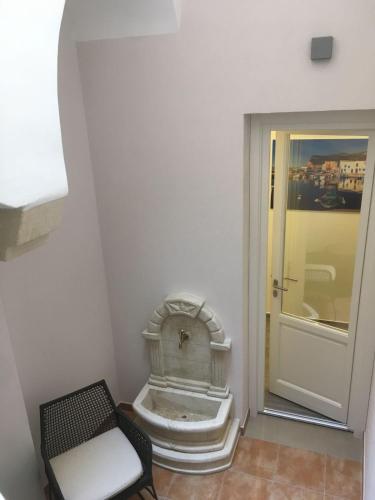 a room with a chair and a clock next to a door at B&B Marconi in Favignana