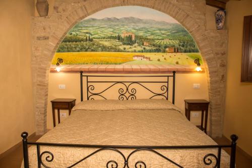 a bedroom with a bed with a painting on the wall at Agriturismo La Casella in San Terenziano