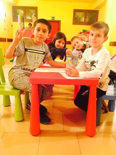a group of children sitting at a red table at Il Leone D'Oro in Telgate