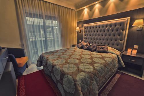 a bedroom with a large bed with a dog laying on it at Hotel Avra in Perea