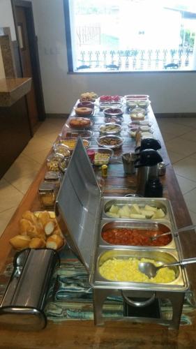 a long table filled with different types of food at Hotel Pousada Trevo in Jequié