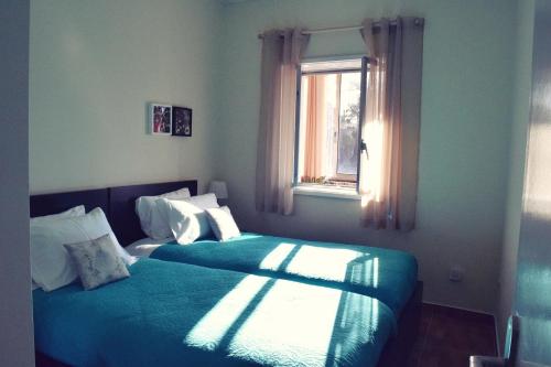 a bedroom with two beds and a window at A Casa da Maria in Porto