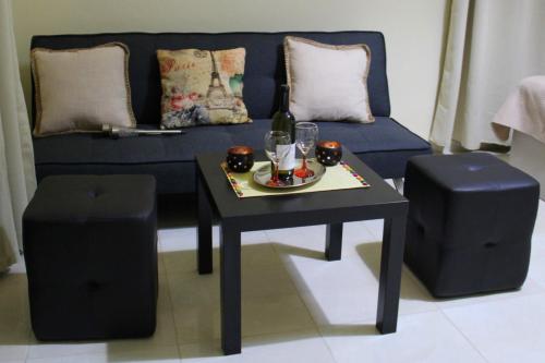 sala de estar con sofá azul, mesa y taburete en Your Home, en Kato Daratso