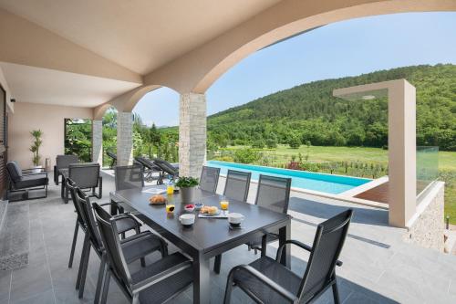 a patio with a table and chairs and a pool at Villa Terra in Labin