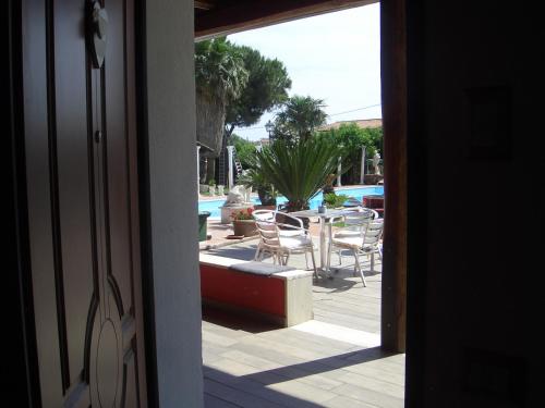 an open door to a patio with a table and chairs at L'oasi di Ambra in Ardea