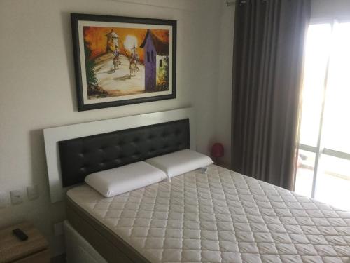 1 cama en un dormitorio con una foto en la pared en Vgfun by Santa Cruz, en Fortaleza