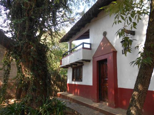 a small white and red house with a red door at Cabañas los Venados in Mazamitla