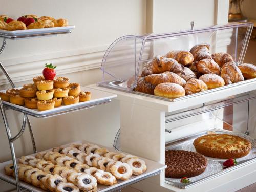 a display case filled with lots of different types of donuts at HNN Luxury Suites in Genova