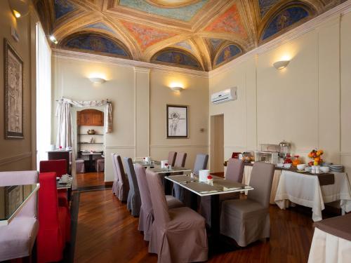 uma sala de jantar com mesas e cadeiras e um tecto em HNN Luxury Suites em Gênova