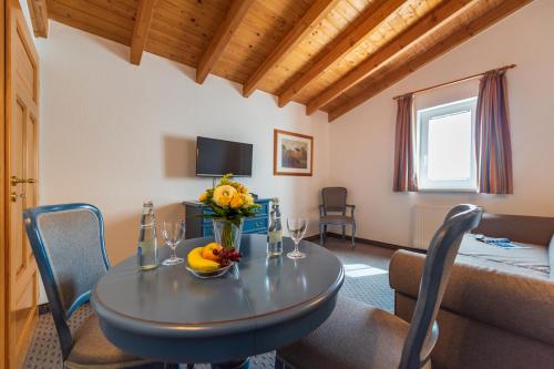 Zimmer mit einem Tisch und einer Vase aus Blumen in der Unterkunft Hotel Garni Getreuer Eckart in Binz