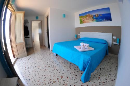 a bedroom with a blue bed with two stuffed animals on it at Le Sette Meraviglie in Castellammare del Golfo