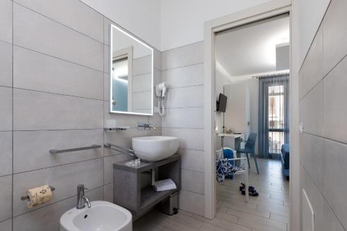 a bathroom with a sink and a toilet and a mirror at B&B Reset confort & relax in San Vito lo Capo