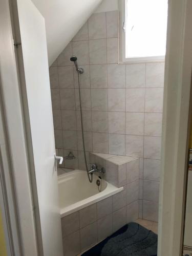 a bathroom with a bath tub and a sink at Liget apartman in Balatonföldvár