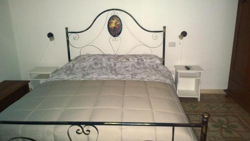 a bed with a metal headboard in a bedroom at Donna Teresa in Mottola