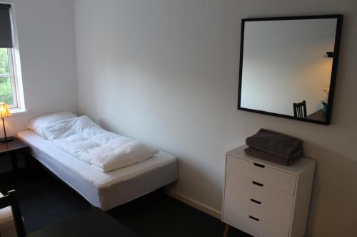a bedroom with a bed and a mirror on the wall at Close But Quiet in Herlev